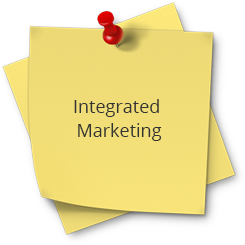 A yellow post it note with the words integrated marketing on top of it.